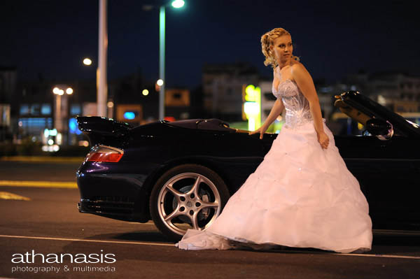η νύφη σε φυσική στάση ολόσωμη έξω από το αυτοκίνητο porsche