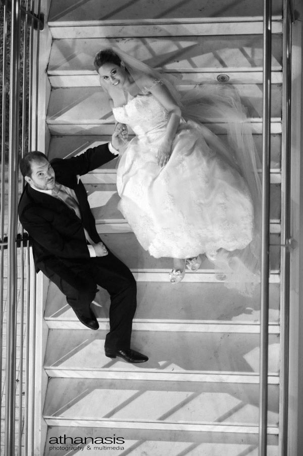 ΟΙ νεόνυμφοι φωτογραφημένη από ψηλά στις σκάλες . Νυχτερινή φωτογραφία γάμου.