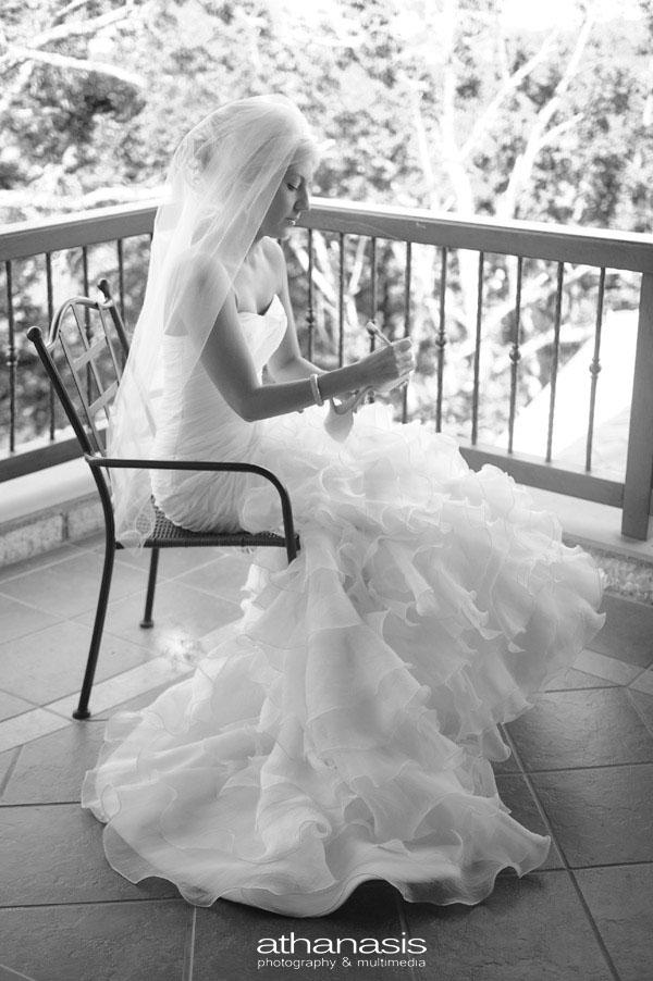 Η νύφη καθισμένη στο μπαλκόνι γραφεί στα παπούτσια , ασπρόμαυρη φωτογραφια γάμου .
